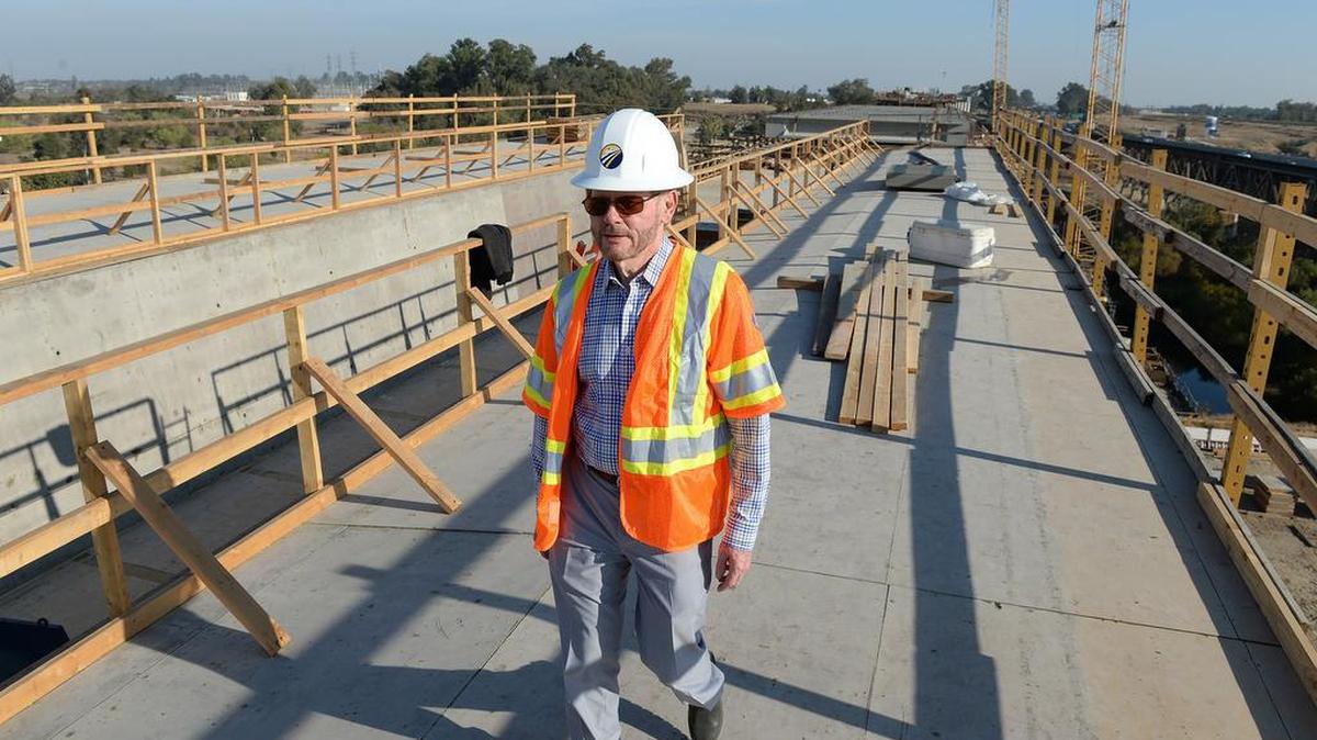 An employee of the California High-Speed Rail Authority walks along the deck of a bridge being built over the San Joaquin River near Fresno.