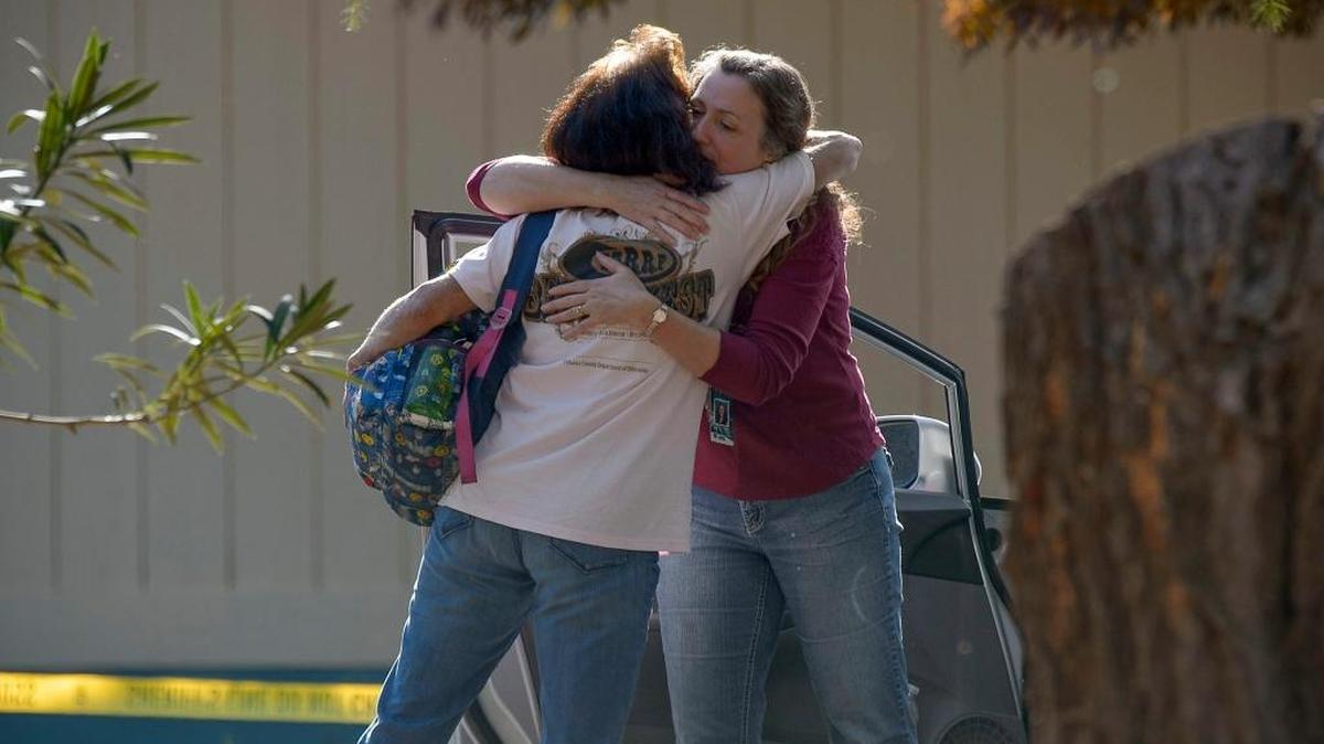 Two unidentified school officials embrace on the grounds of the Rancho Tehama Elementary school, one scene in Tuesday’s shooting; though student was shot, none was killed.