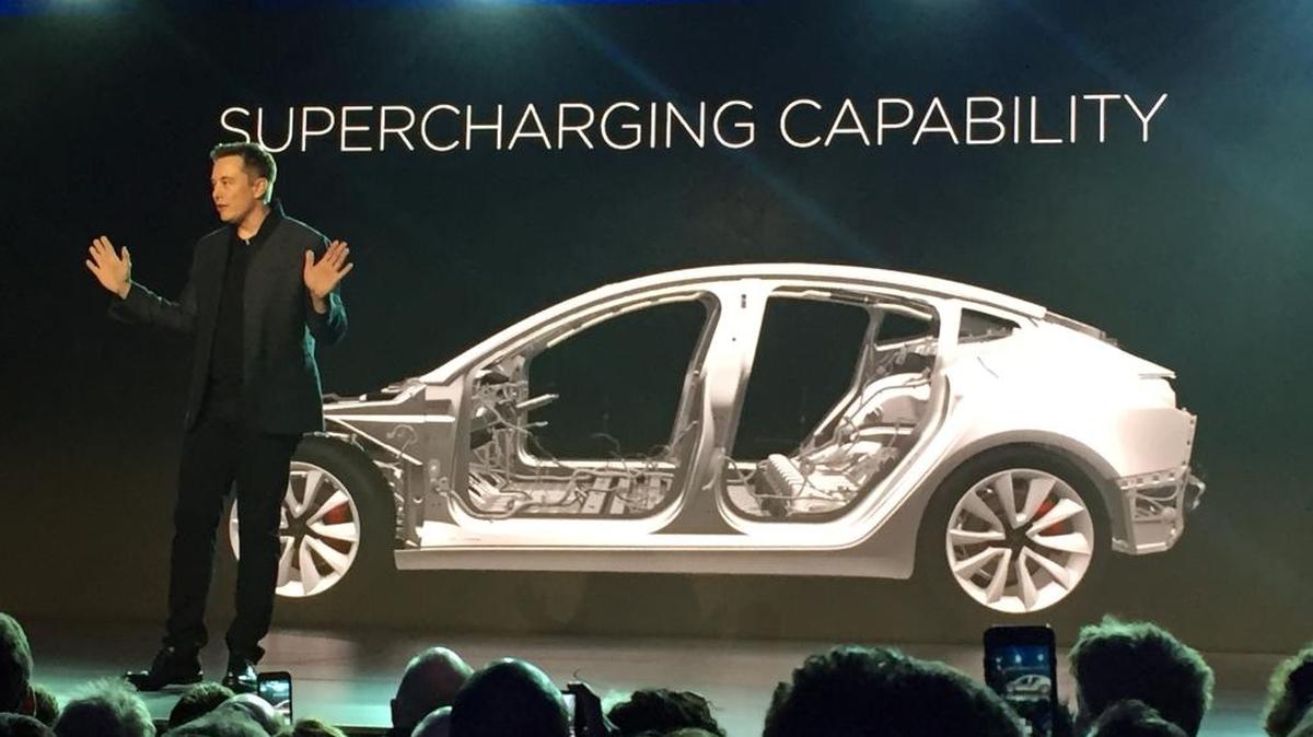 Tesla Motors Inc. CEO Elon Musk speaks at the unveiling of the Model 3 at the Tesla Motors design studio on March 31 in Hawthorne. The promise of an affordable electric car from Tesla Motors had hundreds of people lining up to reserve one. At a starting price of $35,000 before federal and state government incentives, the Model 3 is less than half the cost of Tesla’s previous models.