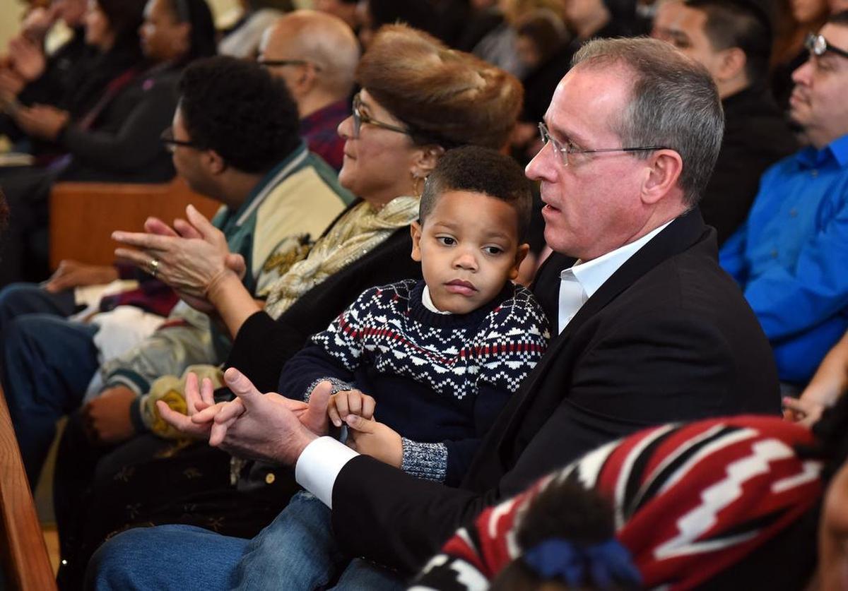 Stanislaus County supervisor Terry Withrow holds Austin Stephenson 3yrs as the two watch the 30th Martin Luther King Jr. Day Service Monday (01-16-17) at Christian Love Baptist Church in Modesto, Calif.