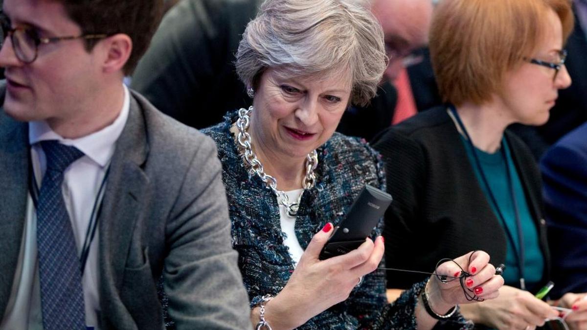 British Prime Minister Theresa May, center, appears to be reacting to something on a smartphone two weeks ago. Thursday she reacted harshly to President Trump’s retweeting of racist, Islamophobic videos distributed by British nationalists.