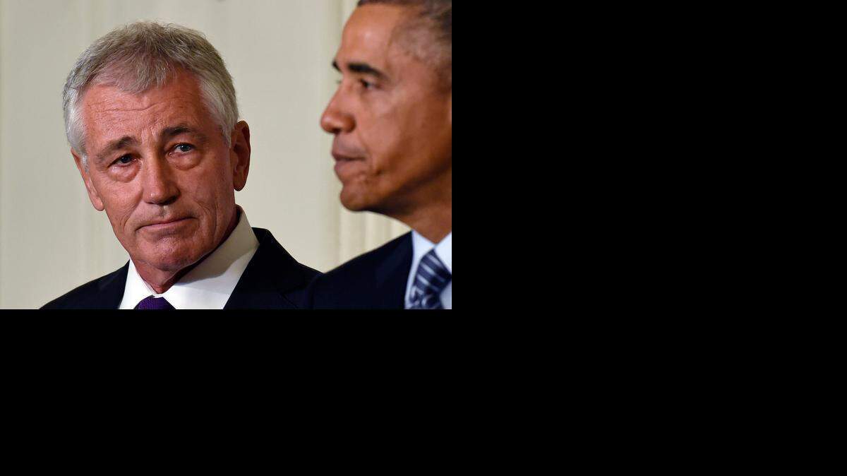 
Defense Secretary Chuck Hagel, left, listens as President Barack Obama talks about Hagel’s resignation in the White House on Monday.
