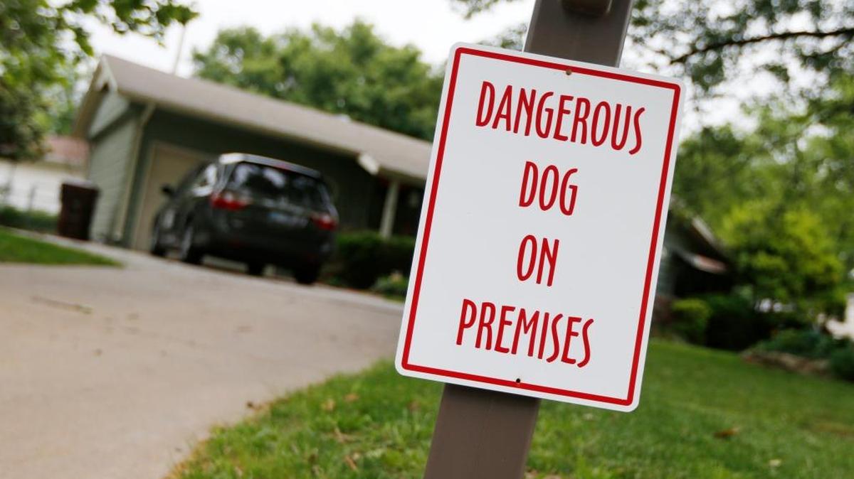 A sign warning of a dangerous dog hangs on the mailbox of a home in Mulvane, Kan.