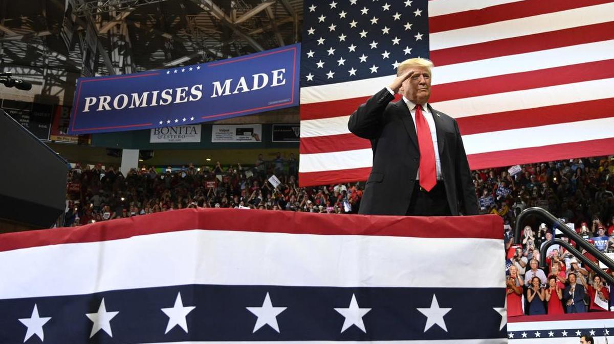 President Donald Trump, who was excused from military service during the Vietnam war due to disabilities, salutes during a rally in Estero, Fla..
