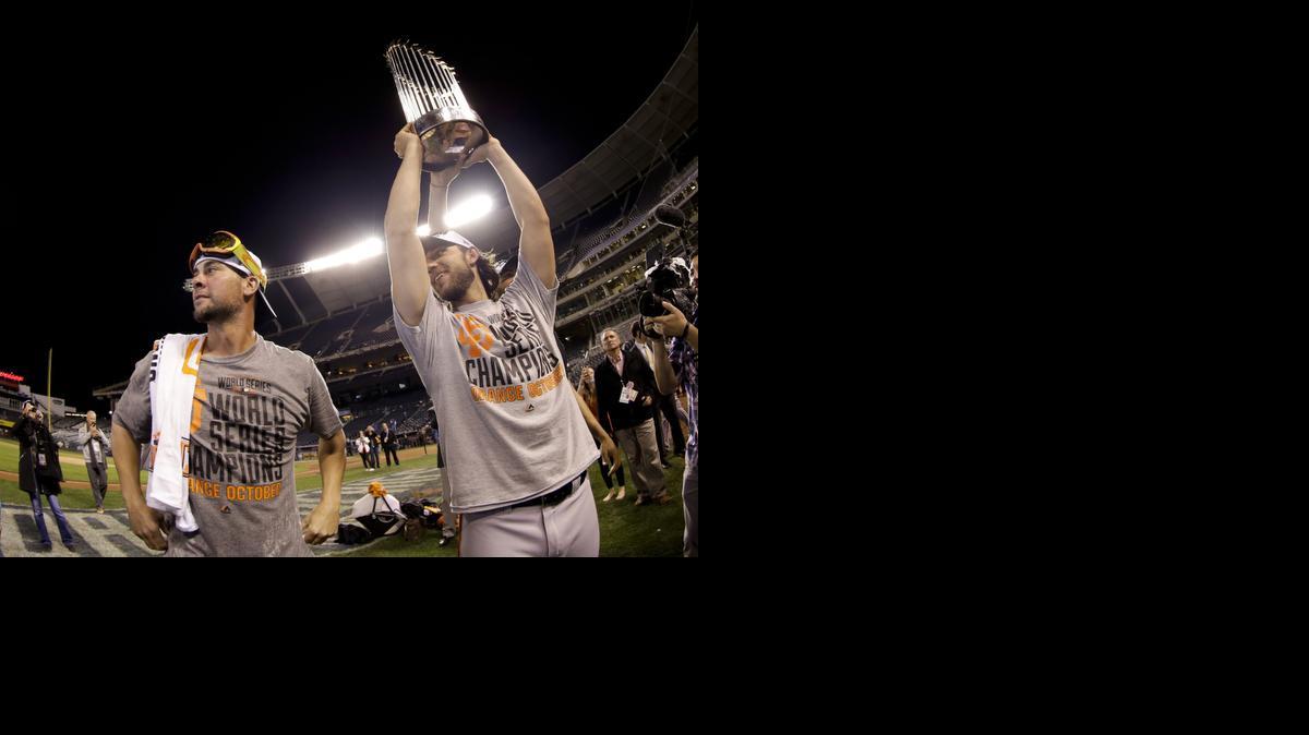 
San Francisco Giants pitcher Madison Bumgarner holds up the trophy after their victory in Game 7 of the World Series against the Royals on Wednesday night in Kansas City, Mo. 
