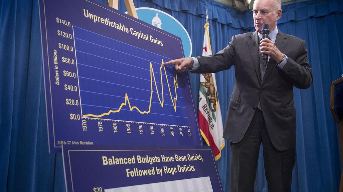 Gov. Jerry Brown shows a graph charting the unpredictable nature of capital gains taxes as he announces his revised budget at the Capitol in Sacramento on Friday.