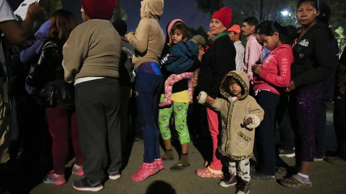 Women wait in line in hopes of receiving donated food and hygiene supplies outside of a sports complex that is sheltering for more than 5,000 Central American migrants in Tijuana. Many of those still waiting are considering a return to the countries they left or applying for asylum in Mexico.