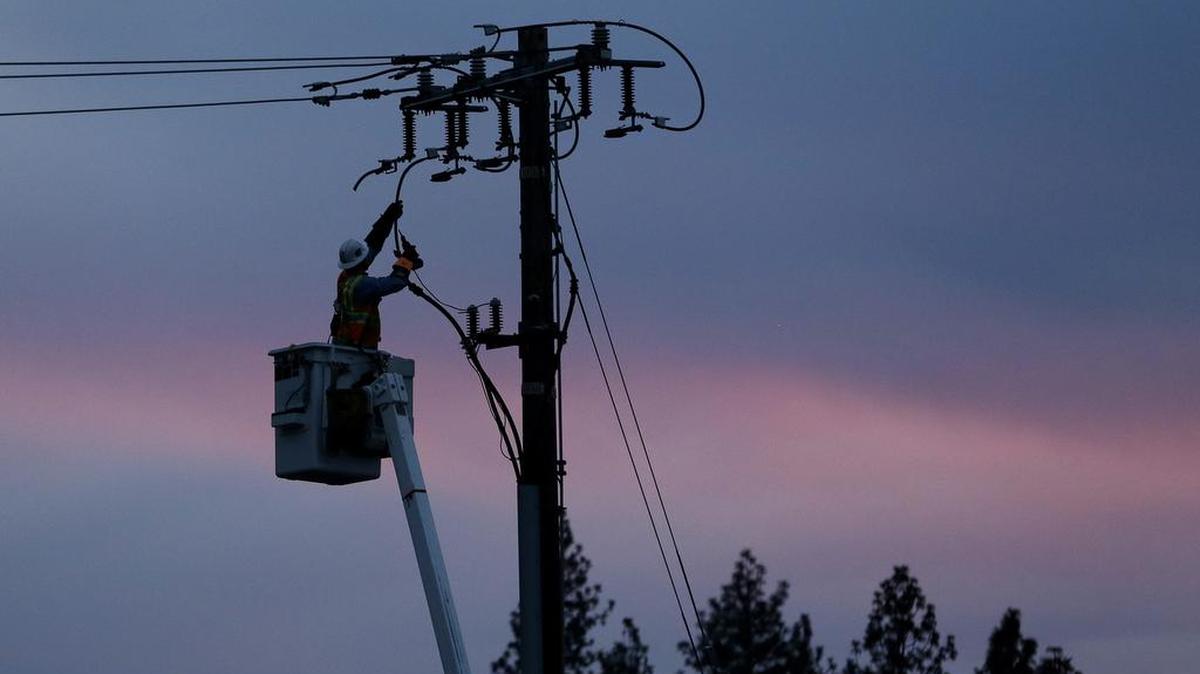 A lineman works to repair a line in fire-ravaged Paradise. Equipment belonging to Pacific Gas & Electric, which served the area, is being blamed for sparking the costliest fire in California history.