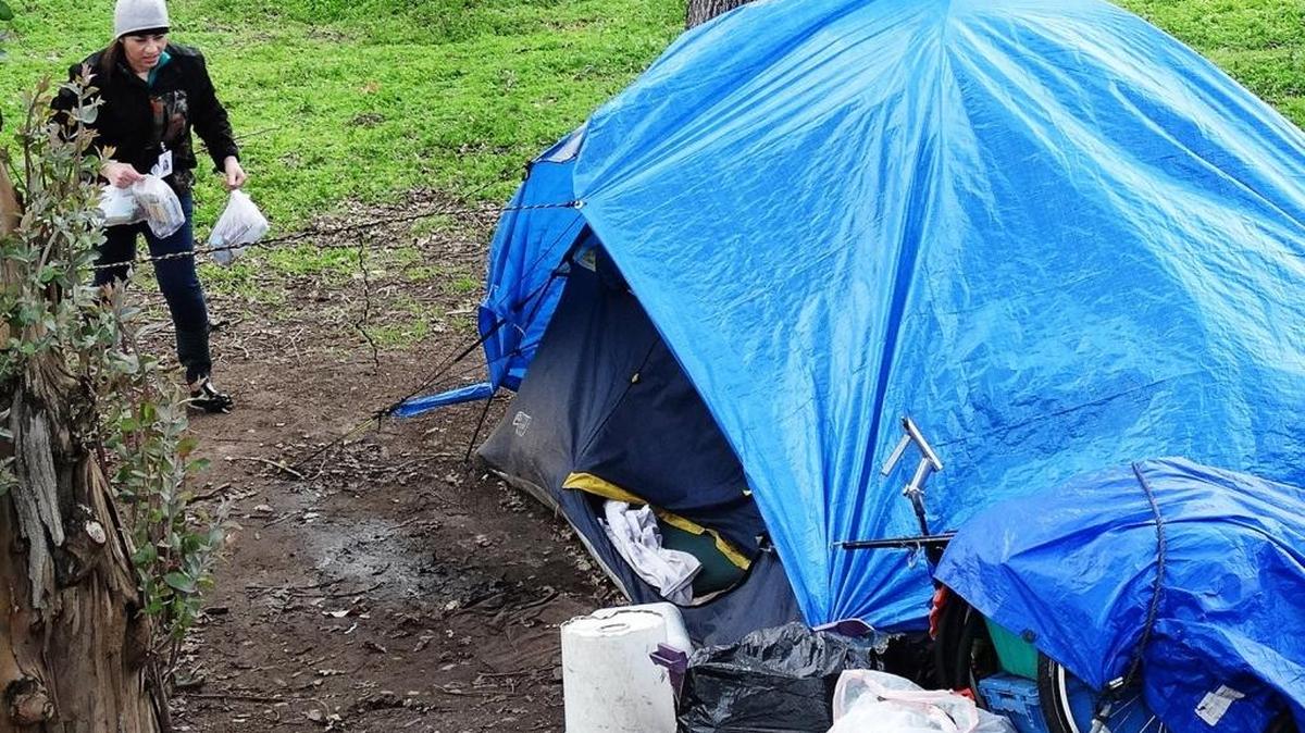 Maria Madrigal, a case manager with Telecare Corp., delivers “goodie bags” to a homeless campsite in Modesto.
