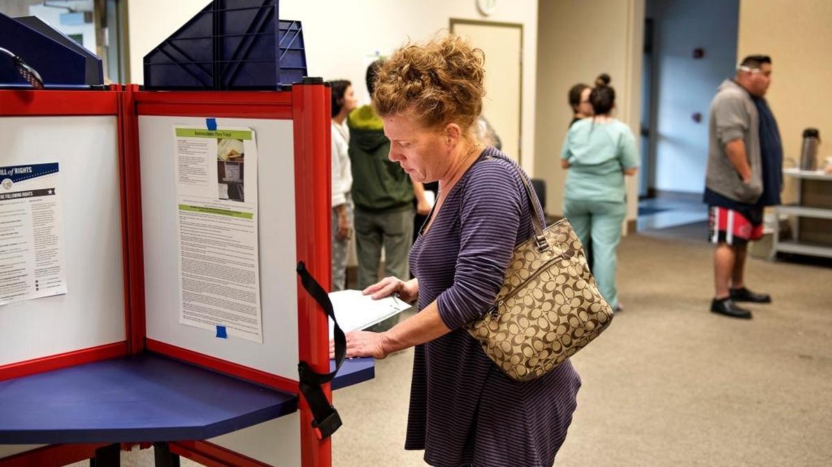 Kathy Mason looks at her ballot as she begins to vote at her polling place at Trinity United Presbyterian Church in Modesto Calif., on Tuesday, November 8, 2016.