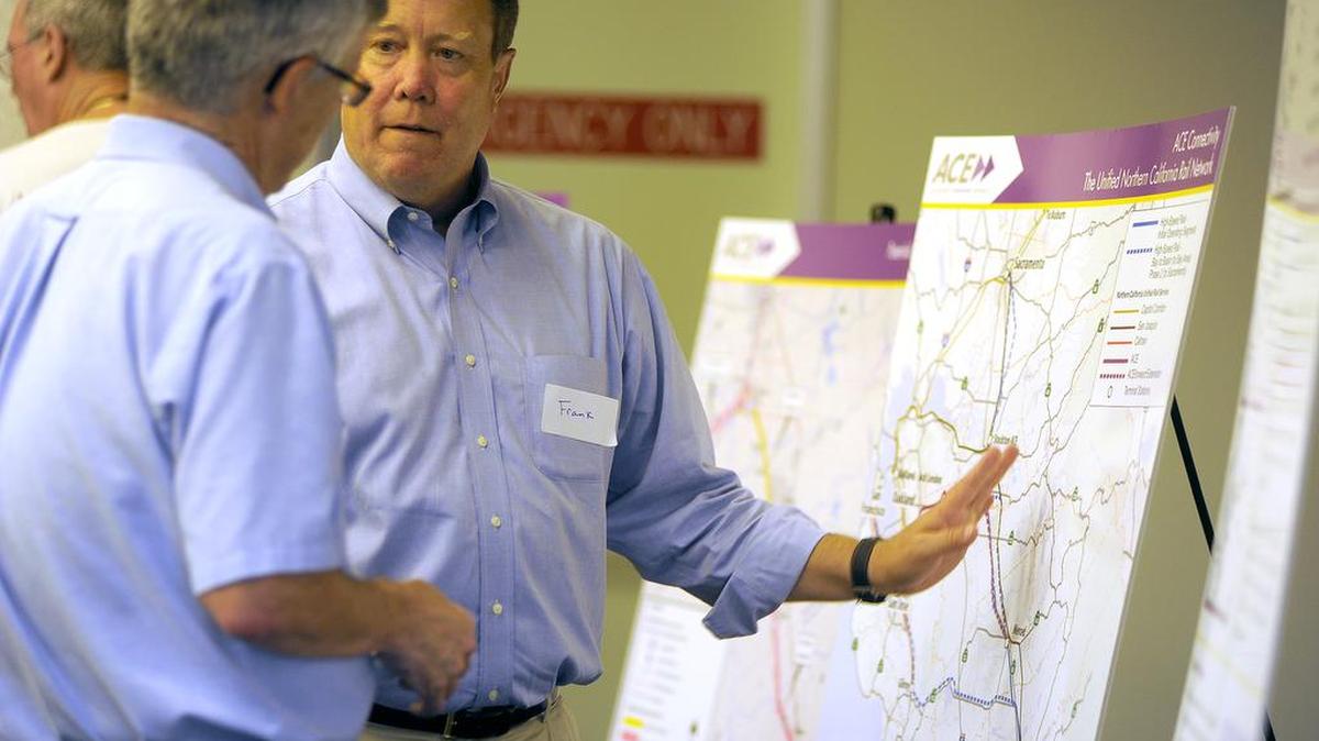 Frank Damrell of Sen. Cathleen Galgiani’s office, talks to Mark Looker about some of the proposed routes during Wednesday’s (07-24-13) ACE Train scoping meeting.