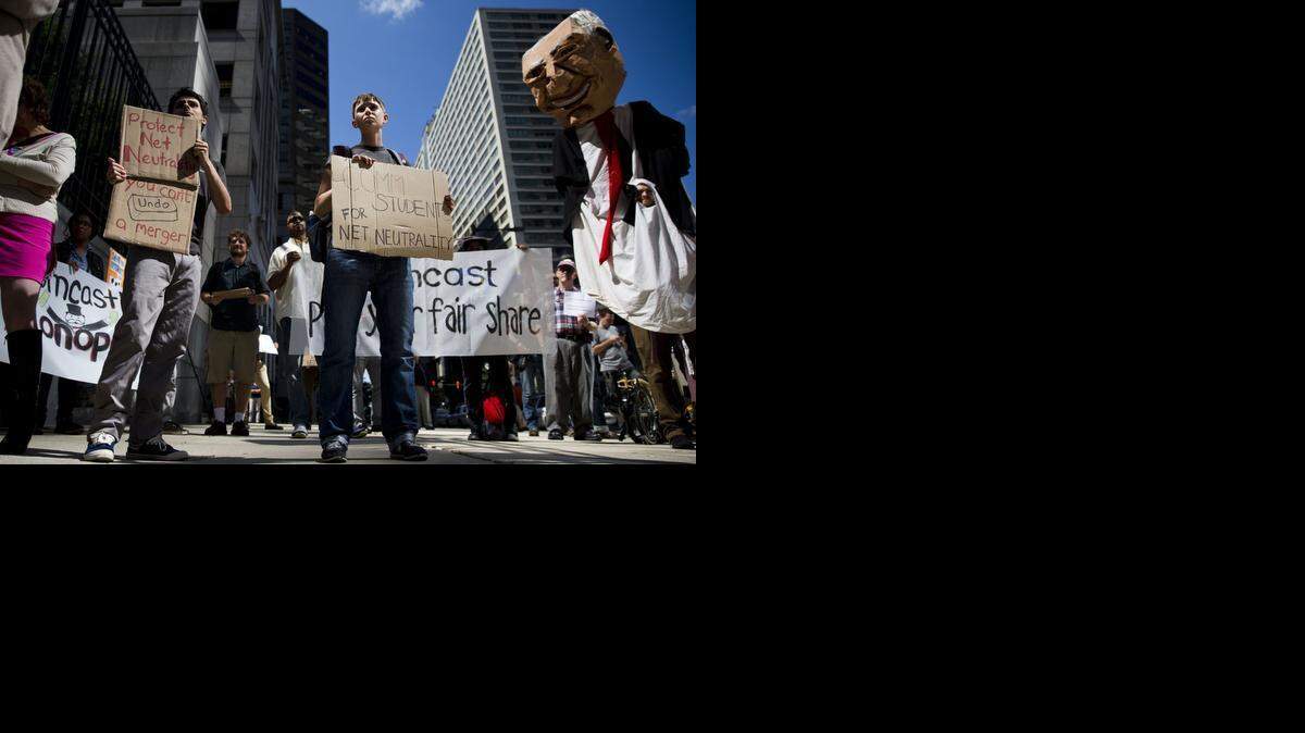 Demonstrators opposed to the Comcast-Time Warner merger gather in Philadelphia in September. A decision on the proposed $45 billion merger is thought to be relatively near.