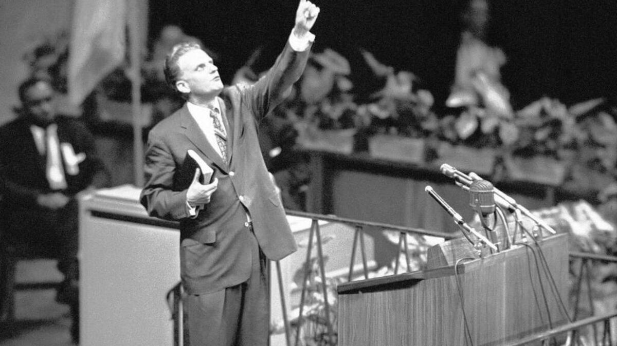 Billy Graham is shown speaking at Madison Square Garden in 1957; in the background, Martin Luther King Jr. can be seen.
