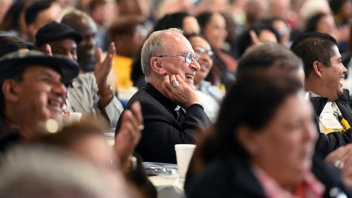 Bishop Stephen Blaire, Diocese of Stockton, enjoys listening to Jose Arrellano, with Homeboy Industries, speak on a panel on racism at the World Meeting of Popular Movements at Central Catholic High School.
