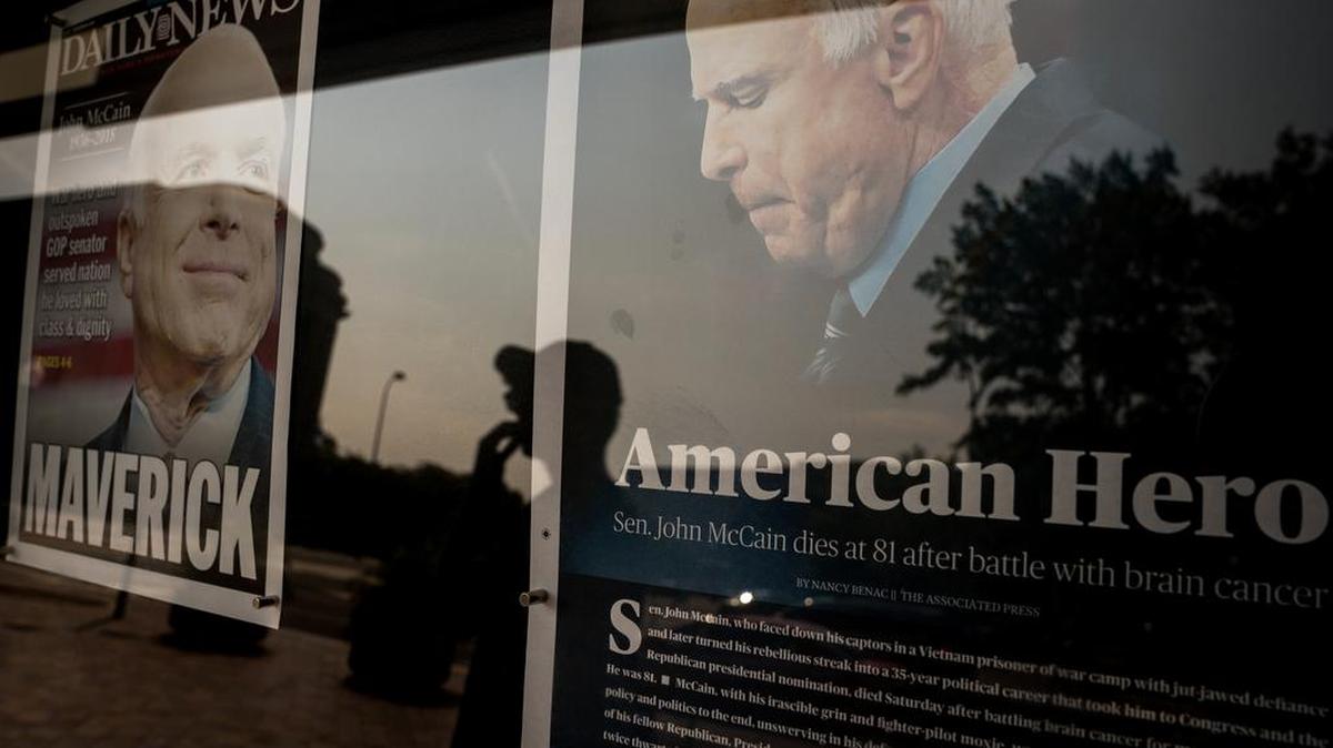 People look at the front pages of newspapers reporting the death of Sen. John McCain outside the Newseum in Washington.