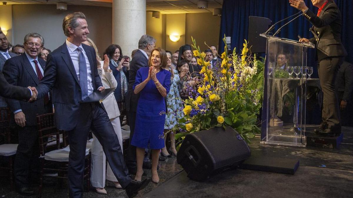 Eleni Kounalakis, right, jokes with Gov. Gavin Newsom, left, as House Speaker Nancy Pelosi, center, cheers them on after Kounalakis was sworn in as lieutenant governor at the Tsakopoulos Library Galleria on Jan. 7.