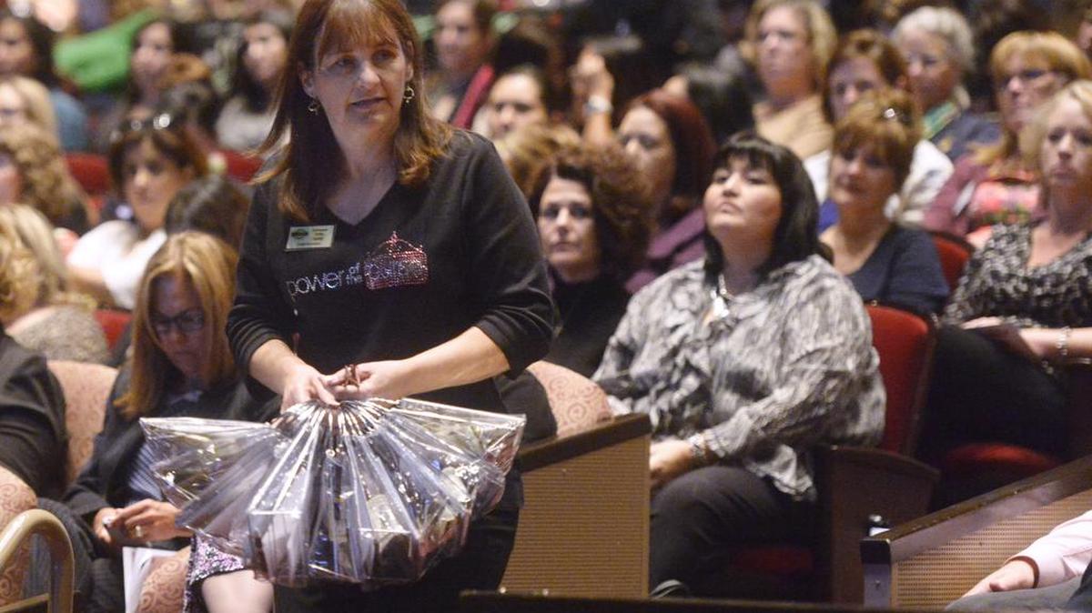 Kathy Hobby, with United Samaritans, collects some of the purses filled with money during a fundraising event at the Gallo Center in 2013. She is volunteer of the year for the Association of Fundraising Professionals.