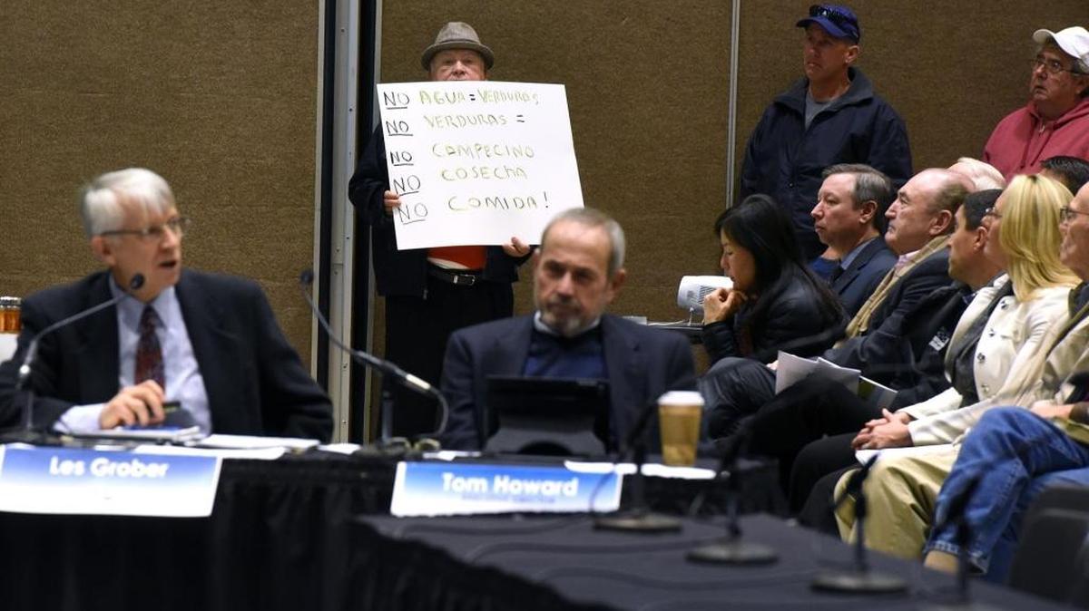 An activist holds a sign as he listens to the presentation by State Water Resources Control Board staff at Modesto Centre Plaza on the state’s proposal to boost environmental flows on the Stanislaus, Tuolumne and Merced rivers. Vance Kennedy spoke shortly after the state’s presentation.