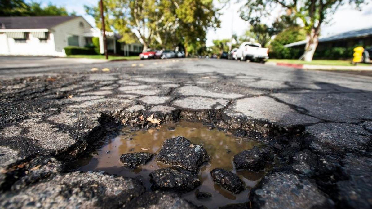 A pothole filled with water on a local street; road conditions in Stanislaus County are among worst in the state.