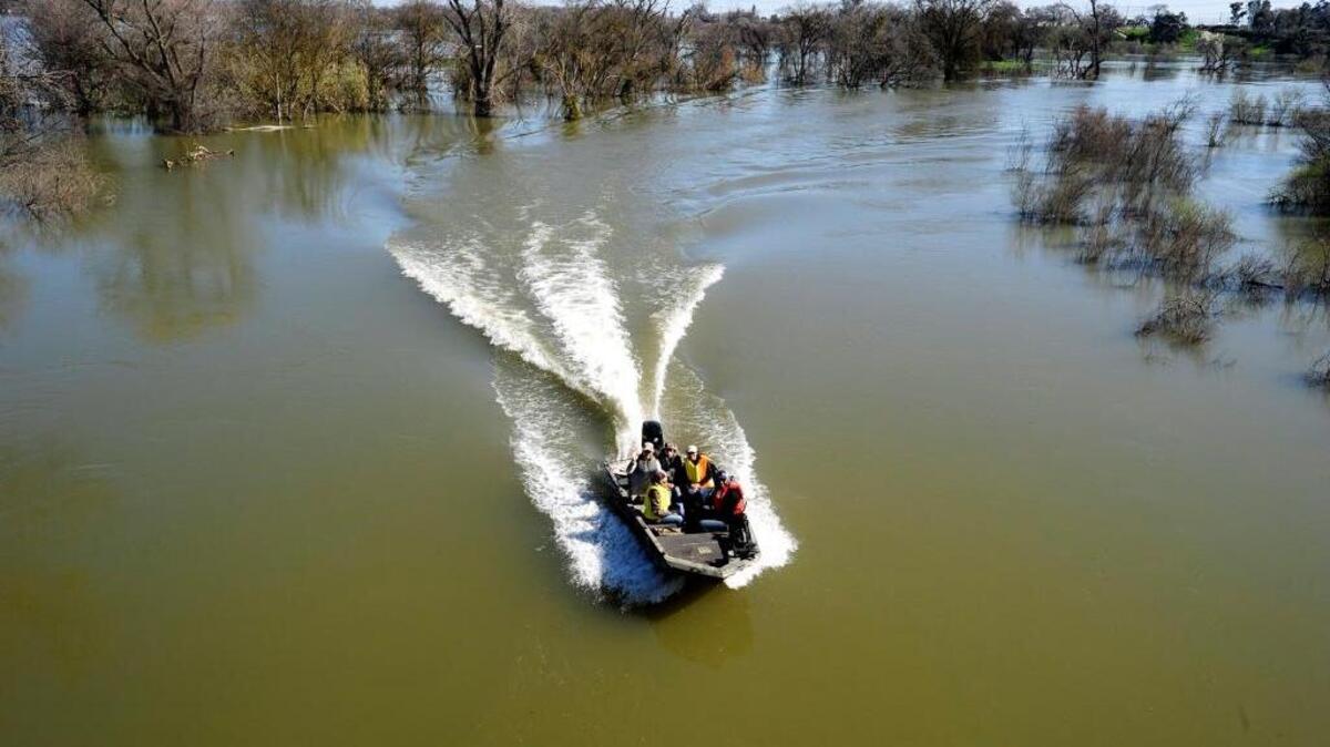 Looking from Mitchell Road east, boaters make their way through flooded land near River Oaks Golf Course. A broader floodplain along the Tuolumne River has a large number of benefits when there is too much water.