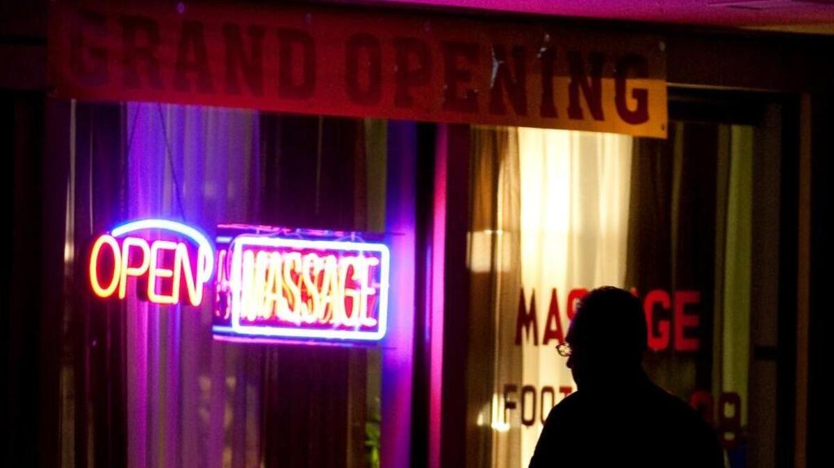 A police officer walks in front of a massage parlor, since closed, in Modesto.