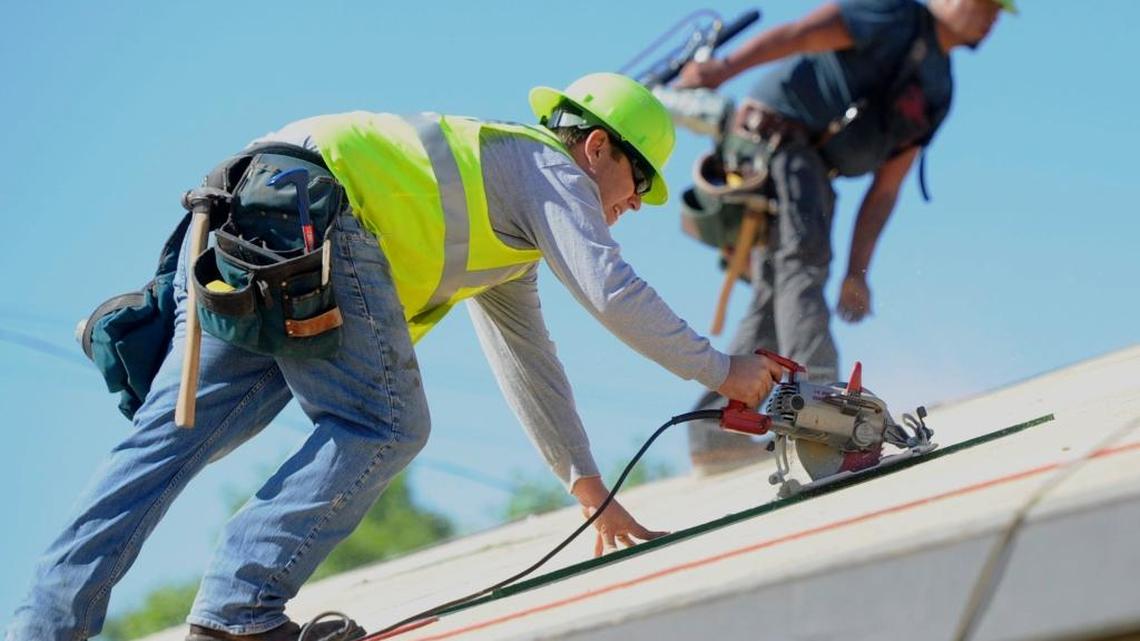 Construction workers on a roof in Modesto, where the median price for a new home hit $355,000 in December 2020.