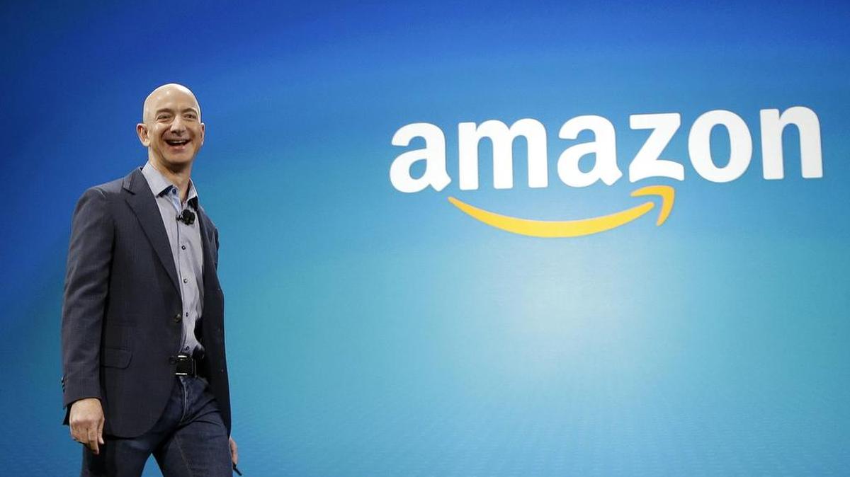 Amazon CEO Jeff Bezos helps launch a new phone. His company hasn’t paid any corporate income tax for two years.