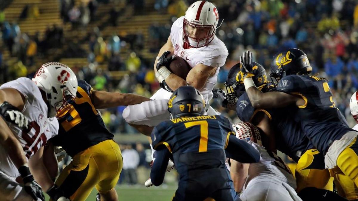 Stanford running back Christian McCaffrey jumps over Cal defenders on a 1-yard touchdown plunge on Saturday, Nov. 19, 2016, in Berkeley.