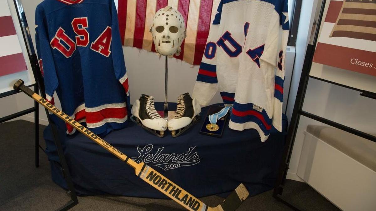 A display featuring 1980 U.S. Winter Olympics hockey goalie Jim Craig’s Olympic gold medal, the jerseys, the hockey skates, and goalie equipment he wore in the Soviet and Finland games and the iconic American flag that was draped over his shoulders after the gold medal win, are displayed during a news conference, Tuesday, May 24, 2016, in New York. Craig, the hockey goaltender who helped the U.S. win a miraculous gold medal at the 1980 winter Olympics, is auctioning off the items.