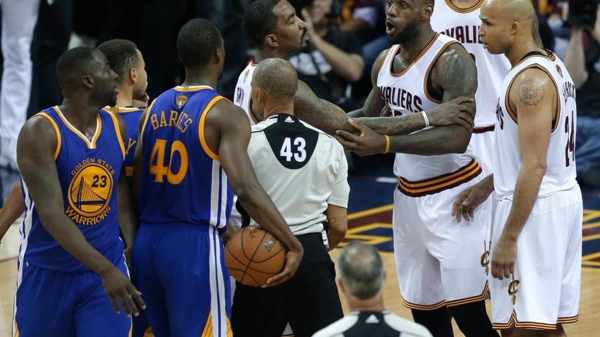 A teammate holds Cleveland star LeBron James back after his Game 4 run-in with Warriors forward Draymond Green (23). Green was suspended for Monday’s Game 5 for delivering a shot to James’ groin.