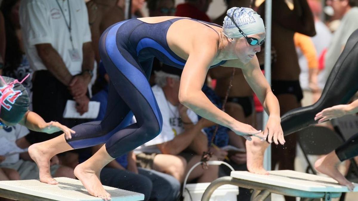 Karlee Bispo of Downey High jumps from the starting block in the 100 Freestyle. Section Swimming Championships at Tokay High School in Lodi.