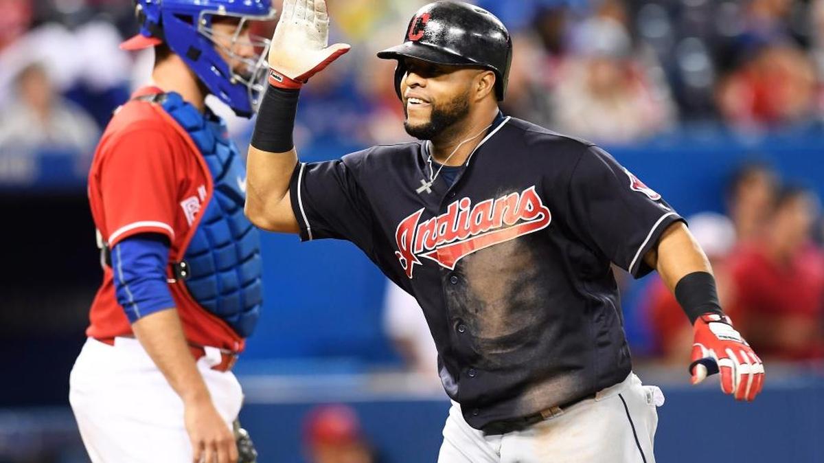 Cleveland Indians designated hitter Carlos Santana celebrates his home run in front of Toronto Blue Jays catcher Josh Thole during the 19th inning of a baseball game in Toronto on Friday, July 1, 2016. The Indians won 2-1 in 19 innings.