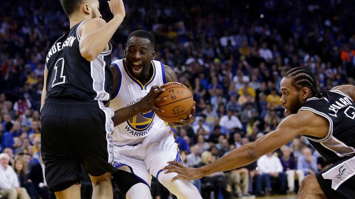 The Golden State Warriors’ Draymond Green drives between San Antonio Spurs’ Kyle Anderson (1) and Kawhi Leonard on Thursday, April 7, 2016, in Oakland.