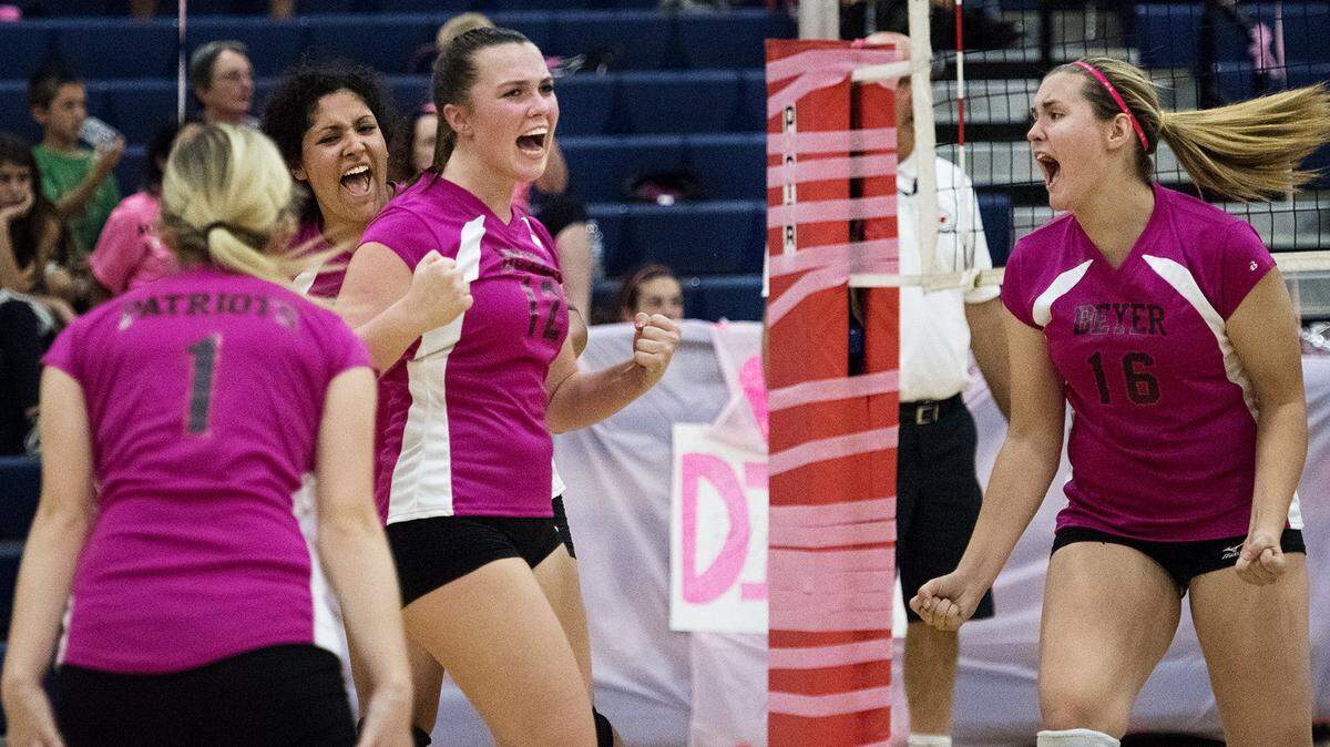 Beyer's Riley Robbins (1), Cathryn Starck (12) and Danielle Ranzo (16) celebrate a point with their teammates during the "Dig Pink" breast cancer awareness game with Downey at Beyer High School in Modesto, Calif., on Friday, October, 9, 2015.