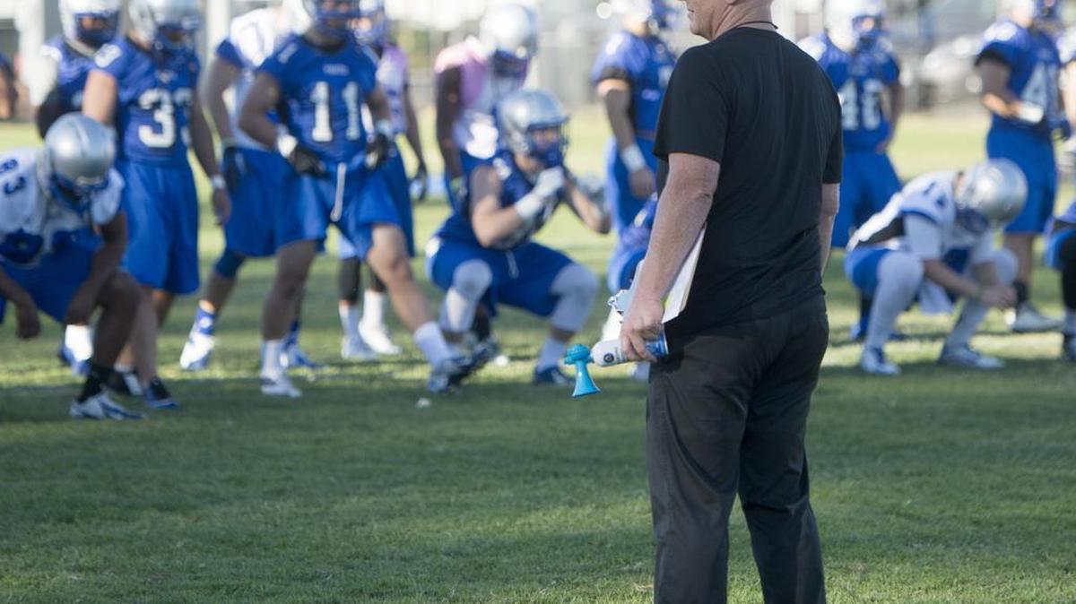 
Head Coach Rusty Stivers watches his team warm up during the first padded practice for the 2015 MJC Football team at Modesto Junior College on Thursday. 
