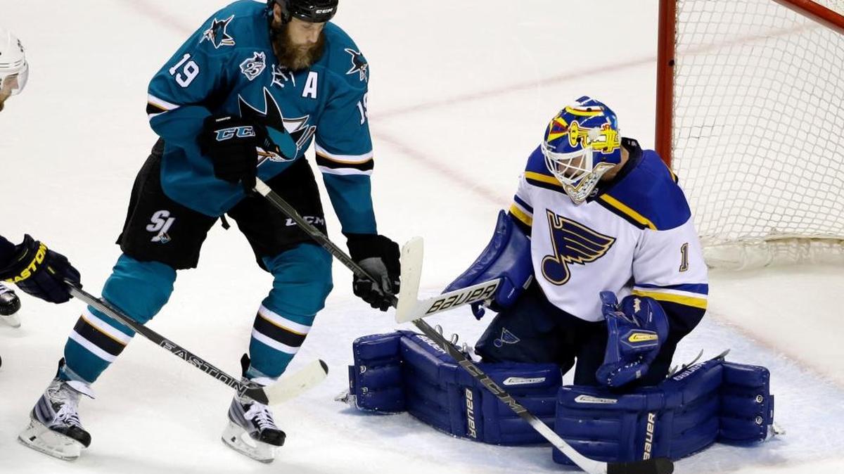 St. Louis Blues goalie Brian Elliott stops a shot next to San Jose Sharks center Joe Thornton (19) during an NHL hockey game Tuesday, March 22, 2016, in San Jose, Calif. St. Louis won 1-0.