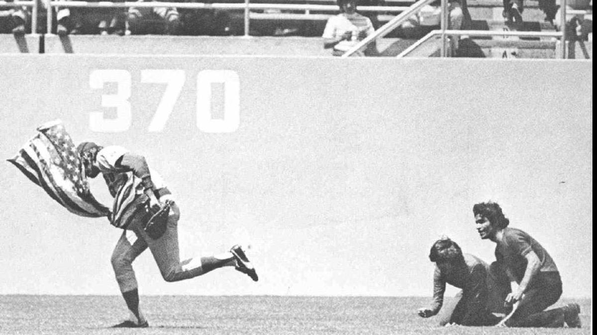 Chicago Cubs outfielder Rick Monday takes an American flag away from two men who were attempting to set it on fire during a major league baseball game at Dodger Stadium on April 25, 1976. The Dodgers marked the 40th anniversary on Monday before they hosted the Miami Marlins.