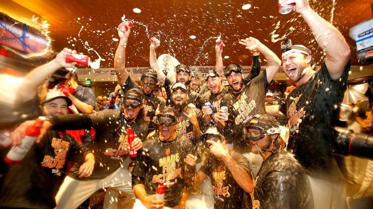 San Francisco Giants players celebrate in the clubhouse after clinching the second National League wild card spot following their 7-1 win over the Los Angeles Dodgers in a baseball game in San Francisco on Sunday, Oct. 2, 2016.