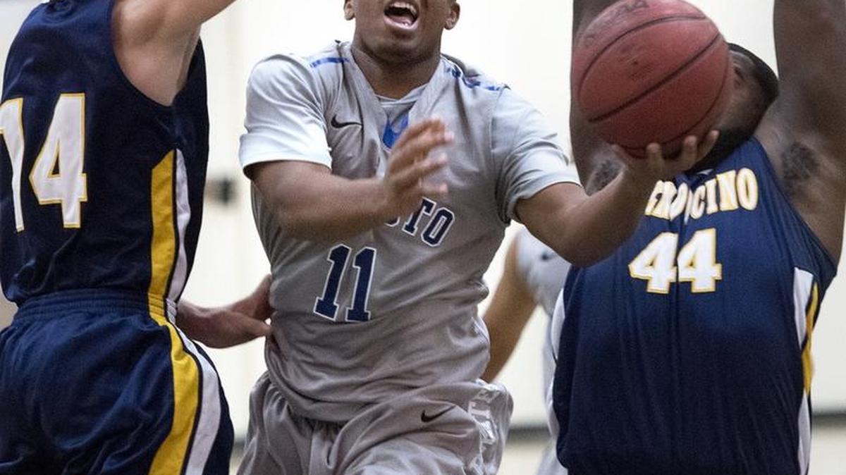 Modesto's Mason Washington attempts a layup past two Mendocino defenders during the Modesto Junior College Invitational at MJC in Modesto, Calif., on Friday, Dec. 18, 2015.