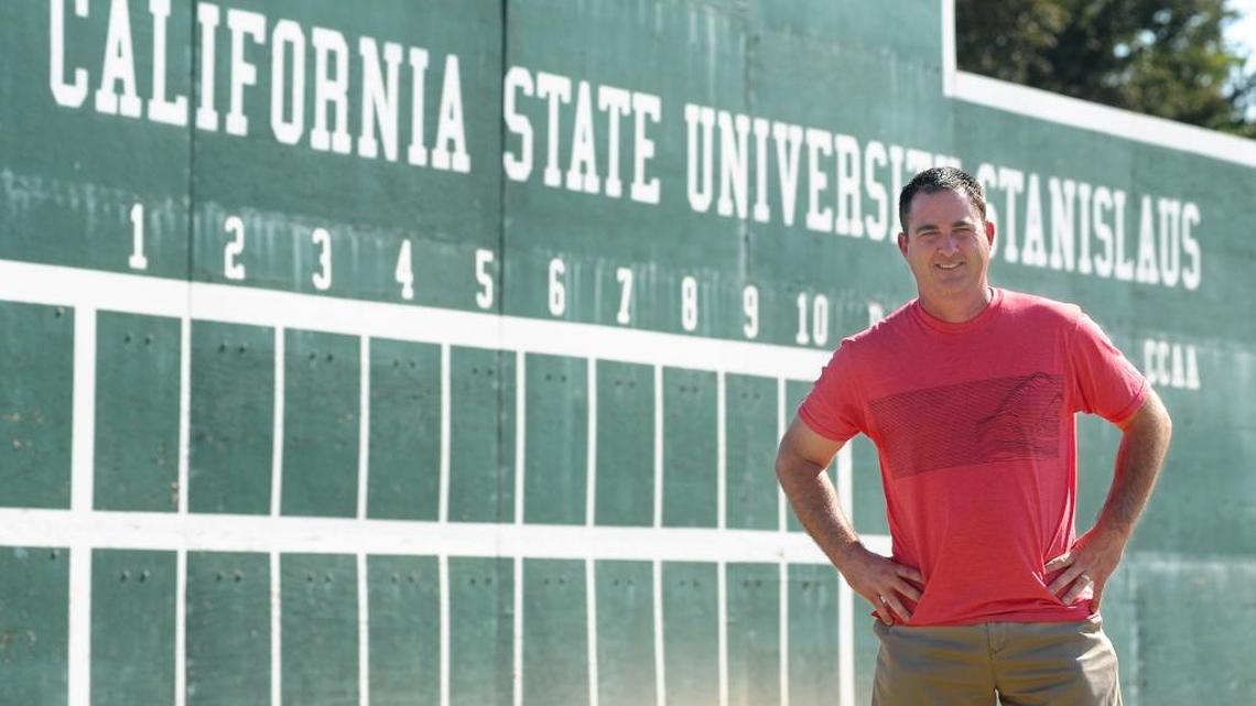 Stanislaus State University athletic director Michael Matoso stands in front of the right field wall at the college’s baseball facility in Turlock where recent changes and upgrades have been made to help foster the success of the program.