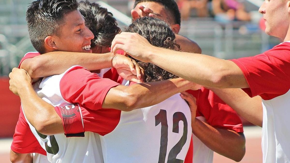 
Cal State Stanislaus’ Manny Villegas, left, is swarmed by teammates after scoring a goal in the 22nd minute during Thursday’s season-opening game against the Academy of Art at Warrior Stadium.
