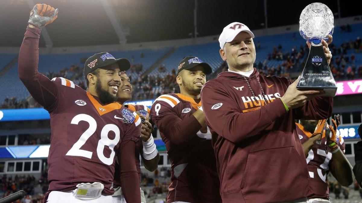 Virginia Tech’s Curtis Williams (28) celebrates as coach Justin Fuente raises the trophy following the Hokies’ 35-24 win over Arkansas in the Belk Bowl in Charlotte, N.C., Thursday, Dec. 29, 2016.