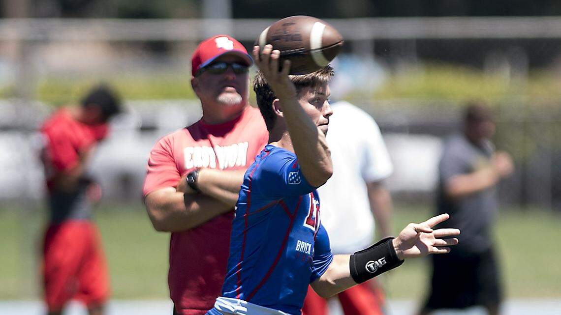 East Union quarterback Jack Weaver makes a pass as offensive coordinator Jason Stock looks on in the background during the MJC Passing Tournament at Modesto Junior College in Modesto, Calif., on Saturday, July 9, 2016.