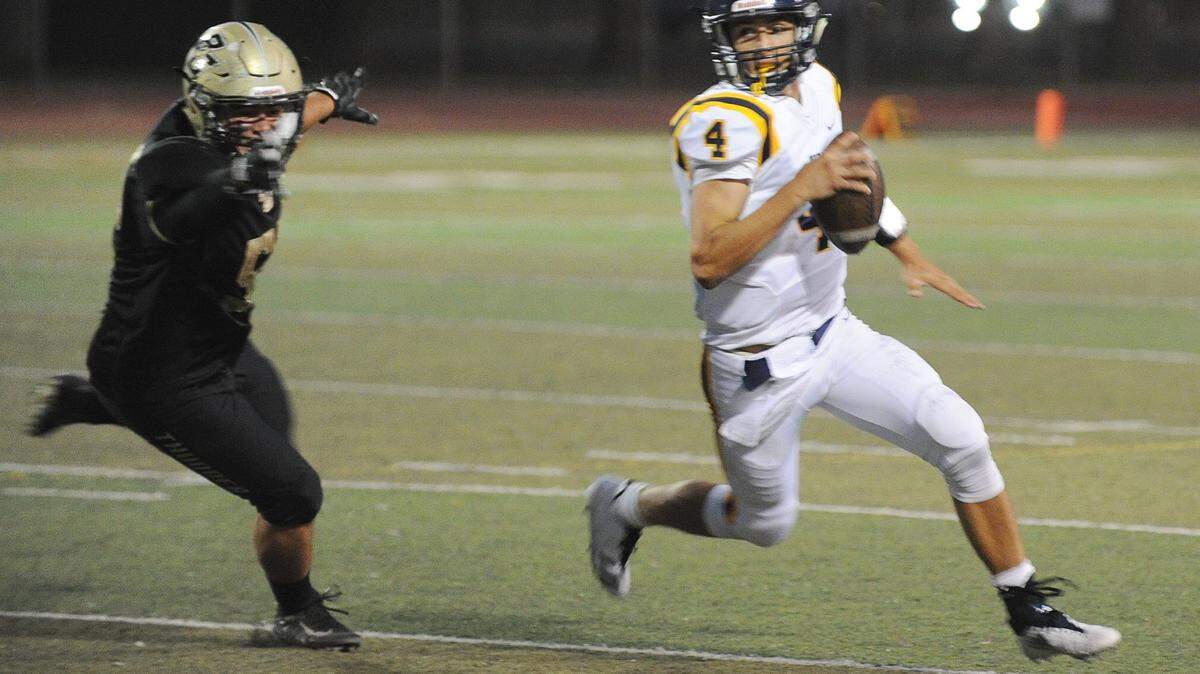 Turlock High quarterback Jonah Kosakiewicz avoid the rush of Buhach Colony defender Noah Perez Fri., Sept. 22, 2017, in Atwater.