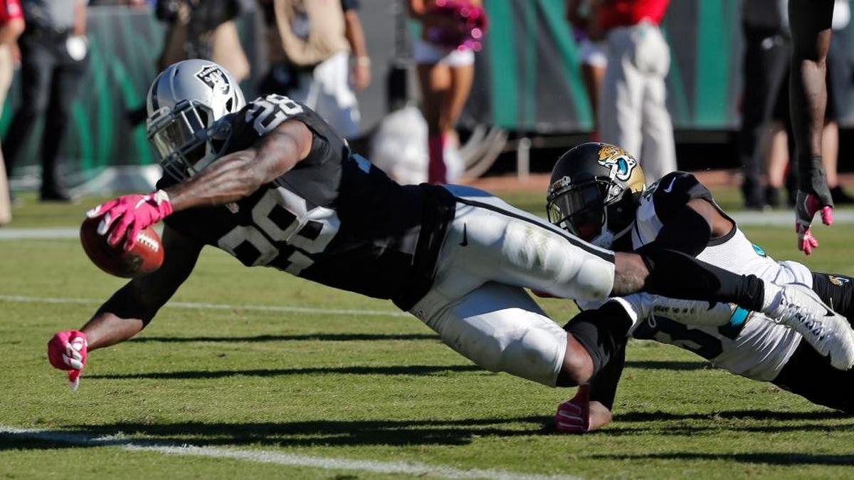 Oakland Raiders running back Latavius Murray (28) is tripped up by Jacksonville Jaguars free safety Tashaun Gipson (39) as he scores a touchdown during an NFL football game Sunday, Oct. 23, 2016, in Jacksonville, Fla.
