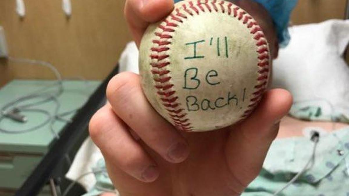 Turlock High senior Damon Treadwell holds up a baseball with the words ‘I’ll be back’ before his Tommy John surgery on Wednesday, March 15, 2017, in Walnut Creek.