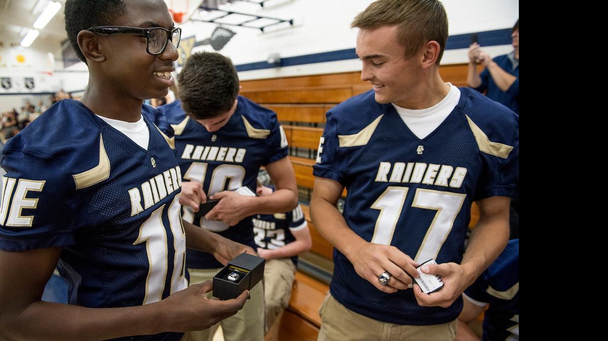 
Central Catholic football players DaRon Bland, left, and Ryan Vierra, right, receive their state championship rings with their teammate at Central Catholic High School in Modesto, Calif., on Thursday, May, 21, 2015.
