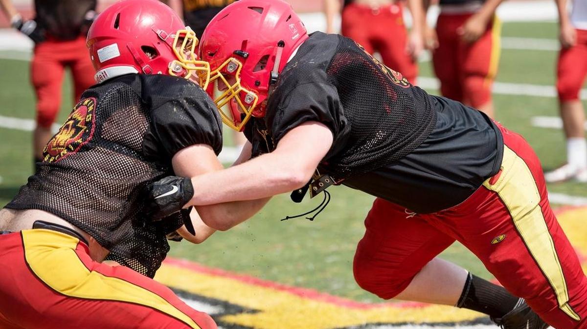 Oakdale defensive lineman Matt Kjeldgaard right works out with a teammate during practice at Oakdale High School in Oakdale, Calif., on Thursday, Aug. 18, 2016.