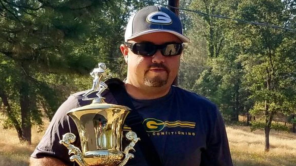 Mariposa High football coach Ryan Oliphant is pictured holding the Green and Gold Trophy, the prize awarded annually to the winner of the Mariposa-Le Grand rivalry game. Oliphant grabbed the trophy before he and his family were evacuated from their home on Tuesday because of the Detwiler fire.