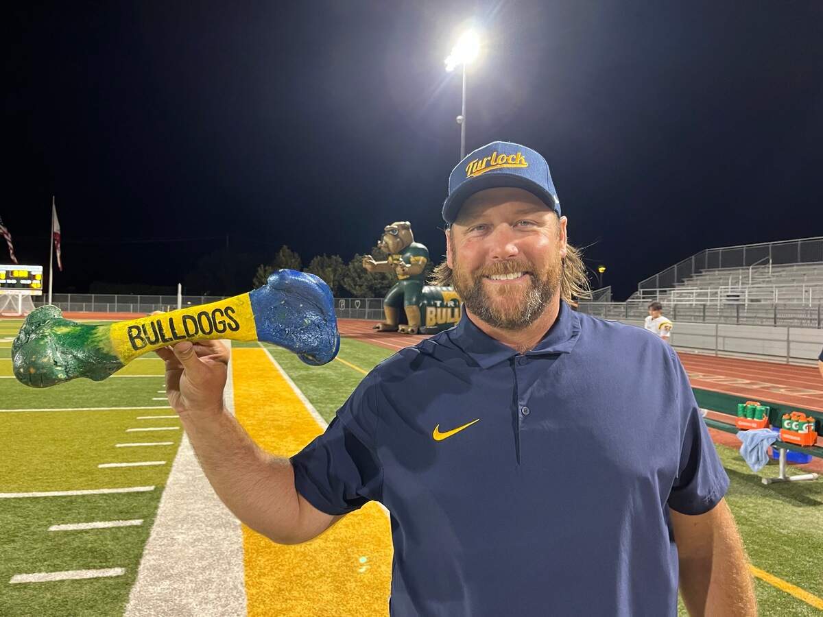 Turlock head coach James Peterson holds the “Battle for the Bone” trophy after 24-19 victory against Tracy at Wayne Schneider Stadium in Tracy, California, on August 30, 2024.